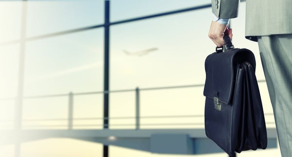 businessman at airport with suitcase in hand