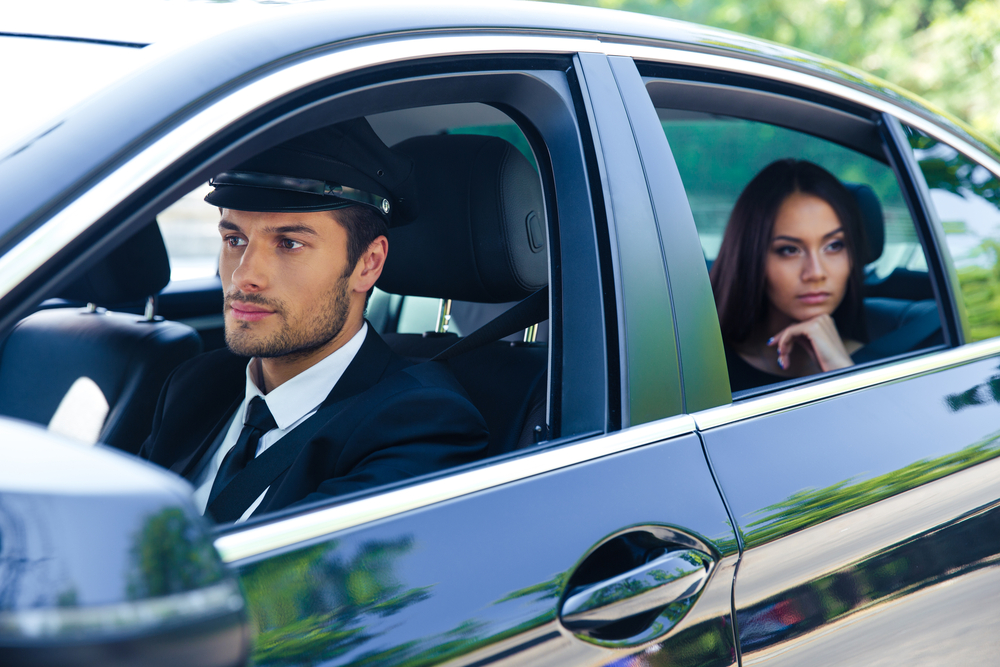 Beautiful woman riding in a car with chauffeur